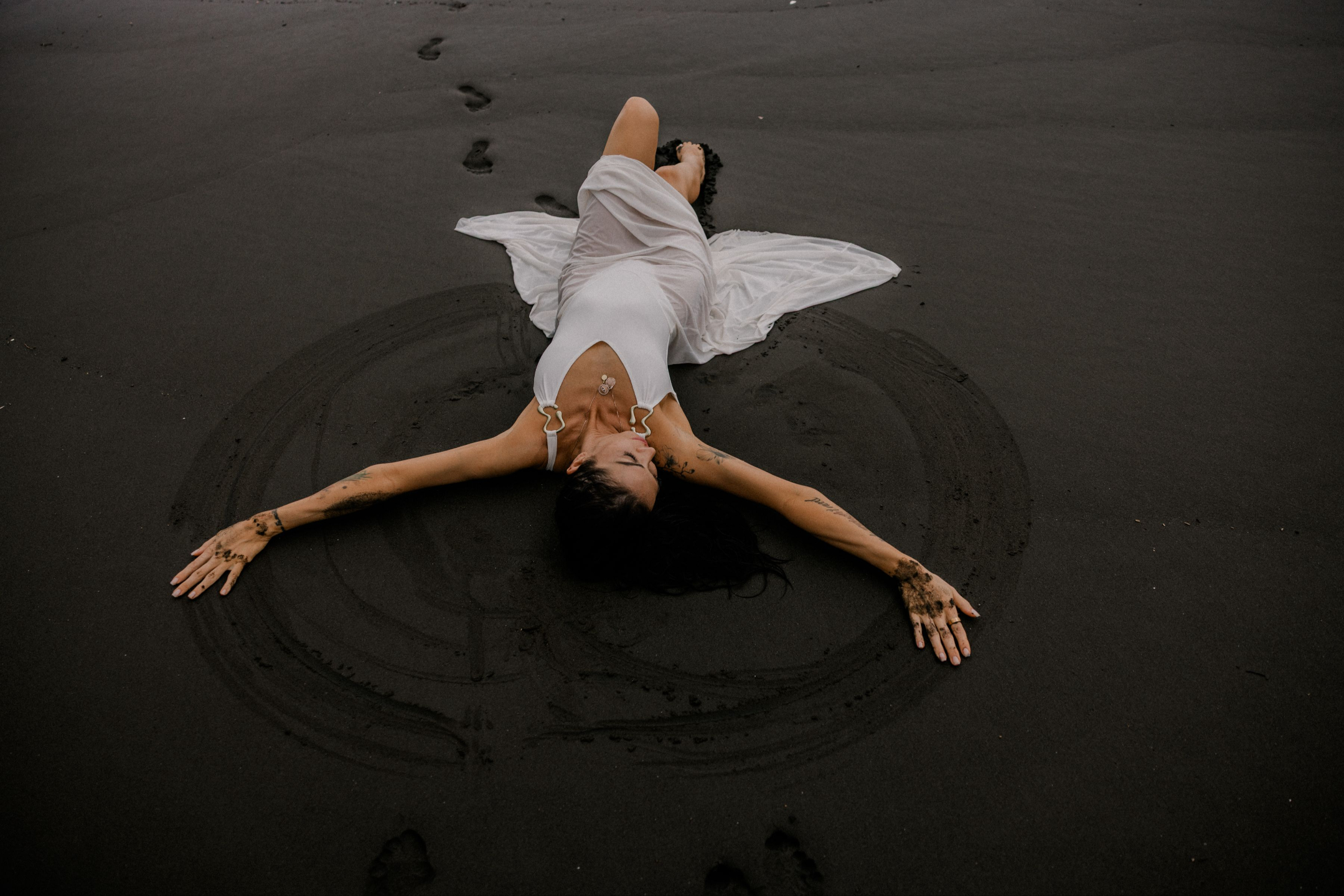 Christina Achkar resting on a dark beach